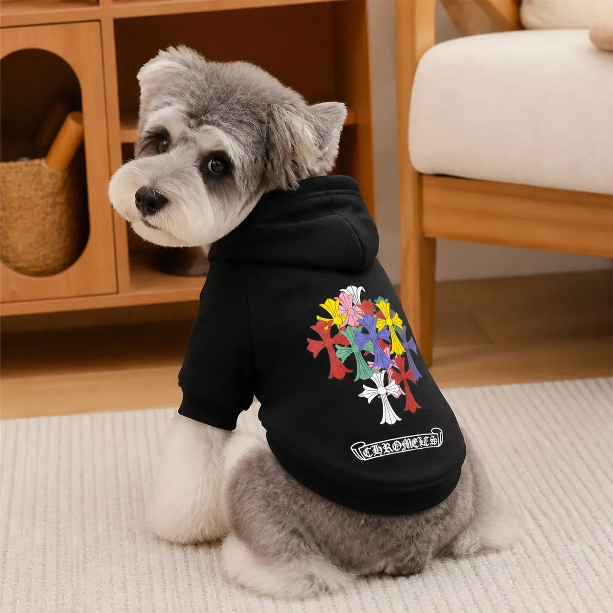 Black Cross Graphic Dog Hoodie worn by a dog in an indoor everyday setting