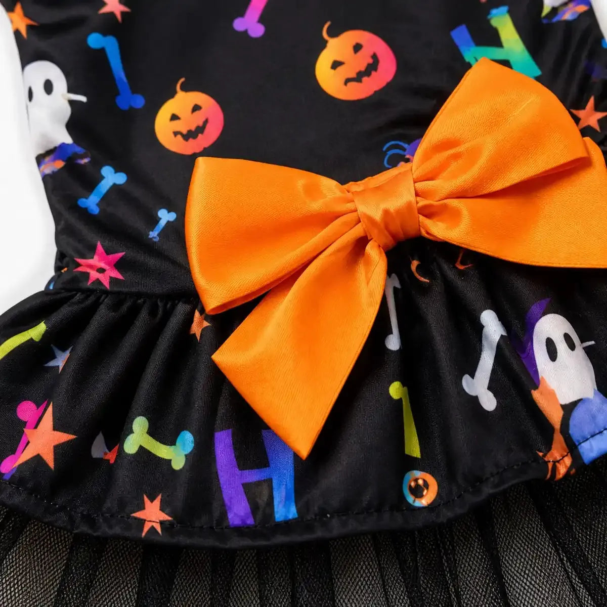 Close-up of the orange bow and colorful Halloween print on a pet dress