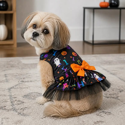 Small dog wearing a black Halloween dress with a layered tulle skirt indoors