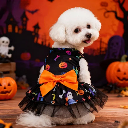 White dog wearing a colorful Halloween print tulle dress with an orange bow in a pumpkin scene