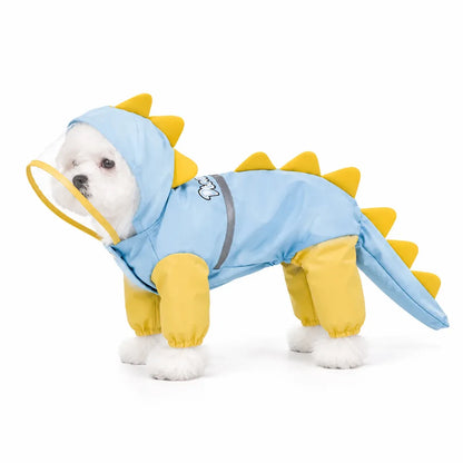 Small dog wearing a light blue dinosaur rainwear suit with yellow spikes on white background